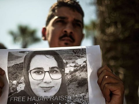 A man carries a banner at a demonstration outside a court in solidarity with detained journalist Hajar Raissouni, in Rabat, Morocco, Monday, Sept. 9, 2019.