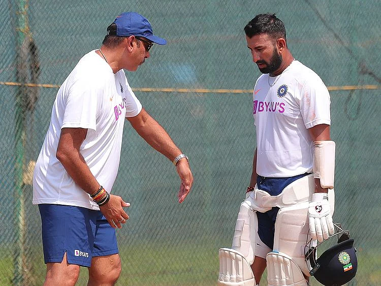 India's Cheteshwar Pujara, right listens to head coach Ravi Shastri 