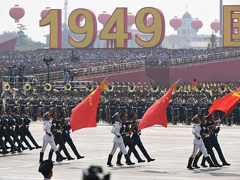 Chinese soldiers march with the national flag, flanked by the flags of the Communist Party of China and the People's Liberation Army (L) during a military parade at Tiananmen Square in Beijing on October 1, 2019, to mark the 70th anniversary of the founding of the People's Republic of China