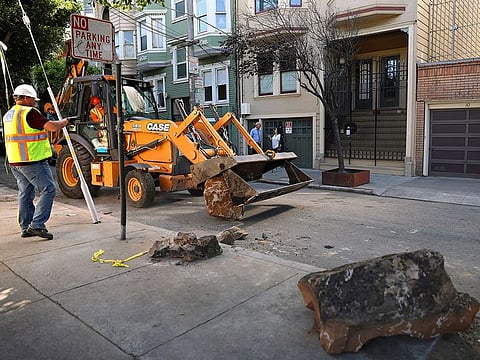 A San Francisco Public Works crew removes boulders from a sidewalk along a street in San Francisco, on September 30, 2019. A group of San Francisco neighbours say they bought boulders and had them delivered to their sidewalk to stop people from camping and dealing drugs on their street. 