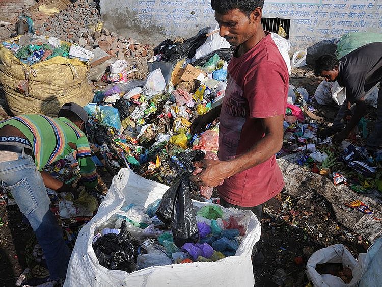 Rag pickers sort plastics at a garbage
