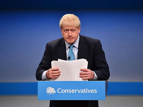 Britain's Prime Minister Boris Johnson shuffles his papers as he delivers his keynote speech to delegates on the final day of the annual Conservative Party conference at the Manchester Central convention complex, in Manchester, north-west England on October 2, 2019