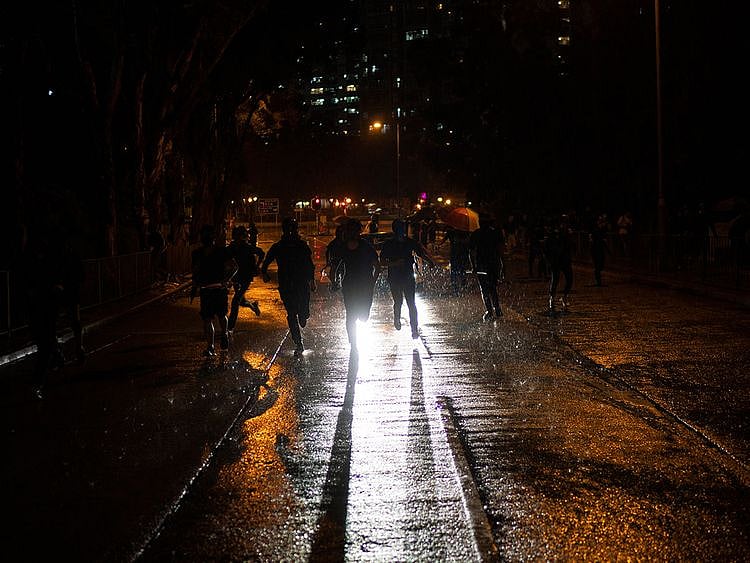 Protestors run away from police in Hong Kong, Sunday, Oct. 6, 2019. 
