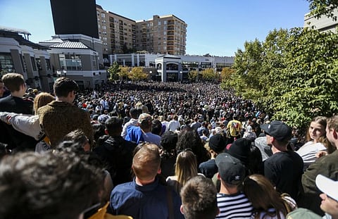 Several thousand people pack into The Gateway mall in Salt Lake City for Kanye West's "Sunday Service" on Saturday, Oct. 5, 2019. People were standing on and climbing up anything they could find to catch a glimpse of West.