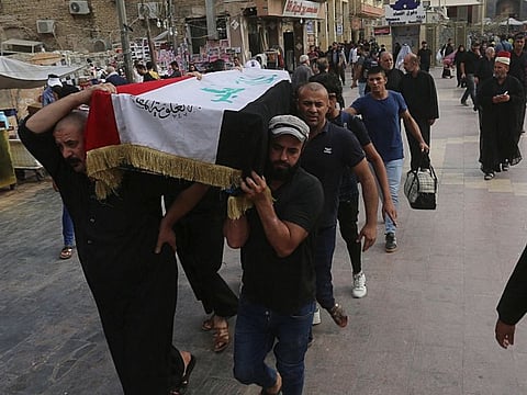 Mourners carry the flag-draped coffin of Hassan Radi, a protester killed during anti-government demonstrations.