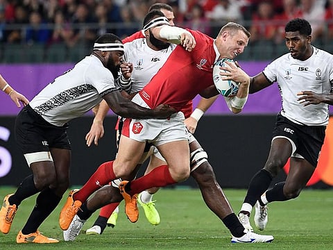 Wales full back Liam Williams (C) is tackled during Rugby World Cup match against Fiji.