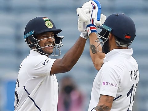 India's Mayank Agarwal (L) celebrates with captain Virat Kohli after scoring a century  on the first day of second test cricket match against South Africa at the Maharashtra Cricket Association Stadium in Pune on October 10, 2019. 
