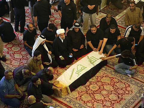 In this Saturday, Oct. 5, 2019 file photo, mourners pray over the flag-draped coffin of a protester killed during anti-government protesters during his funeral at the Imam Ali shrine in Najaf, Iraq. The protests have plunged the country into a new cycle of instability since last week, one that could potentially be the most dangerous this conflict-scarred nation has had to face, with more than 100 killed in less than a week. Iraqi security forces have been shooting at young Iraqis demanding jobs, electricity and clean water and an end to corruption. (AP Photo/Anmar Khalil, File)