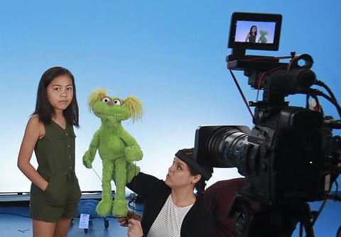 This Aug. 6, 2019 photo shows Salia Woodbury, 10, left, from Irvine, Calif., on the set with "Sesame Street"  muppet Karli and puppeteer Haley Jenkins during a taping about parental addiction in New York. Sesame Workshop is addressing the issue of addiction. Data shows 5.7 million children under 11 live in households with a parent with substance use disorder. Salia's parents are in recovery after struggling with addiction and share her experience with the show's Karli—whose muppet character has a mom who is also in recovery. (AP Photo/Bebeto Matthews)