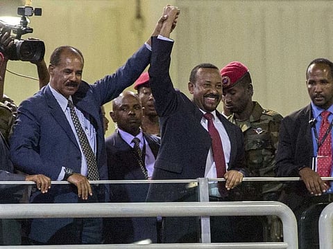 Eritrean President Isaias Afwerki (second left) and Ethiopia's Prime Minister Abiy Ahmed (middle) hold hands as they wave at the crowds in Addis Ababa on July 15, 2018. 