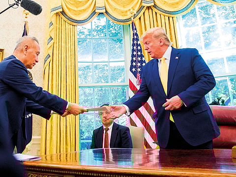 President Donald Trump receives a letter presented to him by Chinese Vice Premier Liu He, left, in the Oval Office of the White House in Washington.