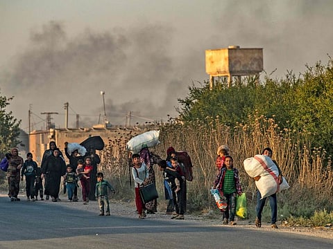 Civilians flee amid Turkish bombardment on Syria's northeastern town of Ras Al Ain in the Hasakeh province along the Turkish border on October 9, 2019.