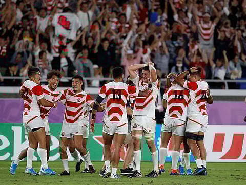 Japan celebrate their World Cup win over Scotland in Yokohama.
