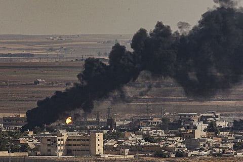 In this photo taken from the Turkish side of the border between Turkey and Syria, in Ceylanpinar, Sanliurfa province, southeastern Turkey, smoke billows from fires on targets in Ras al-Ayn, Syria, caused by bombardment by Turkish forces, Sunday, Oct. 13, 2019