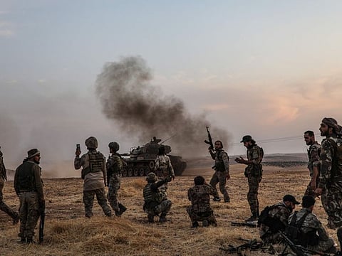 Turkish soldiers and Turkey-backed Syrian fighters gather on the northern outskirts of the Syrian city of Manbij near the Turkish border on October 14.