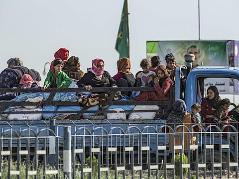 Syrian families fleeing the battle zone between Turkey-led forces and Kurdish fighters from the Syrian Democratic Forces arrive in Tal Tamr on the outskirts of Hasakeh on October 15, 2019. 