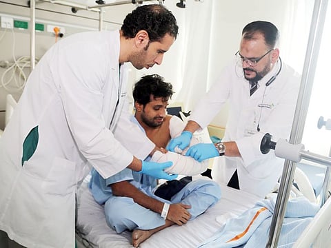 Specialist orthopaedic surgeon with hand specialisation, Dr Mohammad Ali  ( Left ) with patient Flertin Baby and consultant orthopaedic surgeon with specialistaion in hand microsurgery, Dr Hassan Badawi  ( Right)
