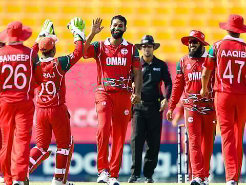 Oman's Khawar Ali celebrates during his three-wicket haul against Hong Kong on Sunday.