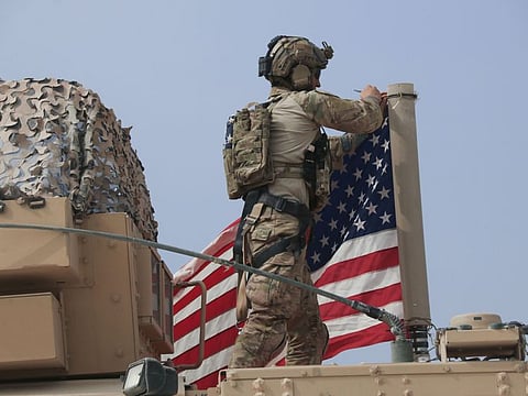 American soldier mount the U.S. flag on a vehicle near the town of Tel Tamr, north Syria, Sunday, Oct. 20, 2019. 