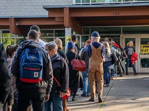 People line up to vote at a polling station for Canada's 43rd general election October 21 in Toronto, Ontario, Canada