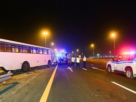 Police tow away the bus in which 21 workers were injured during a crash on Emirates Road on Wednesday night   