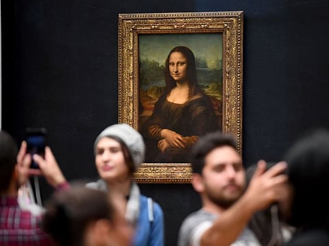 (FILES) In this file photograph taken on October 7, 2019, visitors take photographs in front of The Mona Lisa (La Gioconda) after it was returned at its place at the Louvre Museum in Paris. The Louvre in Paris is putting the finishing touches to an ambitious Leonardo da Vinci retrospective opening on October 24, 2019, which groups more than 160 of the artist's works and has already attracted close to 200,000 advance visitor bookings. Timed to coincide with the 500th anniversary of the famed artist's death, the show, simply called "Leonardo da Vinci", took a decade to put together and includes works on loan from Queen Elizabeth and Bill Gates. - RESTRICTED TO EDITORIAL USE - MANDATORY MENTION OF THE ARTIST UPON PUBLICATION - TO ILLUSTRATE THE EVENT AS SPECIFIED IN THE CAPTION
 / AFP / ERIC FEFERBERG / RESTRICTED TO EDITORIAL USE - MANDATORY MENTION OF THE ARTIST UPON PUBLICATION - TO ILLUSTRATE THE EVENT AS SPECIFIED IN THE CAPTION