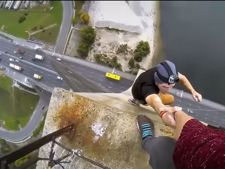 A selfie involving a man, being held by another person