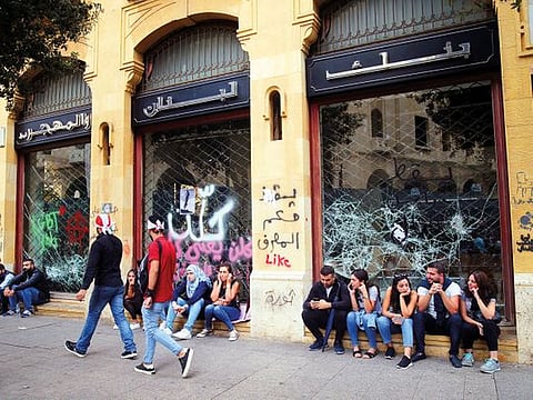 Protesters sit outside a Blom Bank branch in Beirut. 