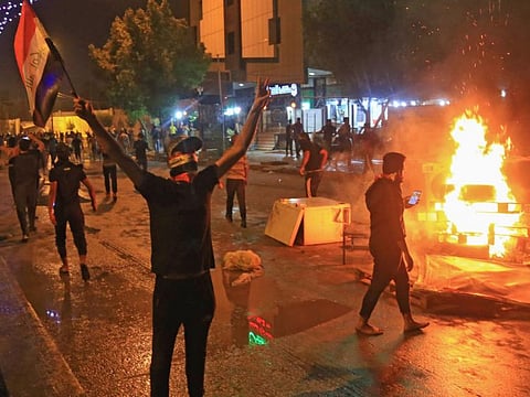 Iraqi protesters burn items to block the road during clashes with security forces following an anti-government demonstration in the Shiite shrine city of Karbala, south of Baghdad, on Friday. 