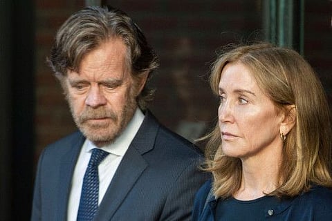 (FILES) In this file photo taken on September 13, 2019 actress Felicity Huffman, escorted by her husband actor William H. Macy, exits the John Joseph Moakley United States Courthouse in Boston, where she was sentenced by Judge Talwani for her role in the College Admissions scandal.