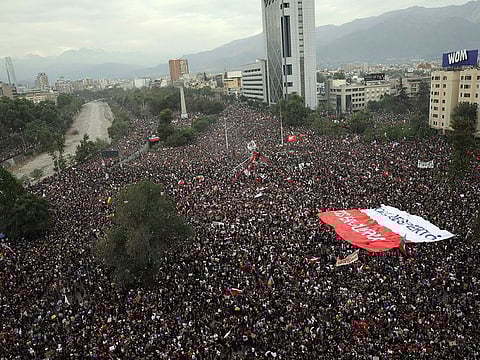 People gather during an anti-government protest in Santiago, Chile, Friday, Oct. 25, 2019. At least 19 people have died in the turmoil that has swept the South American nation.