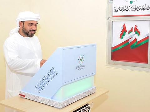 An Omani man casts his ballot.