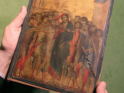 In this Tuesday, Sept. 24, 2019 file photo, art expert Stephane Pinta points to a 13th-century painting by Italian master Cimabue in Paris.