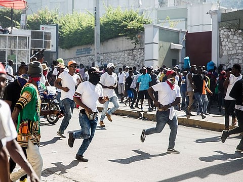 Armed protesters and police officers in plainclothes take to the streets as police officers and their supporters protest in Port-au-Prince on October 27, 2019. 