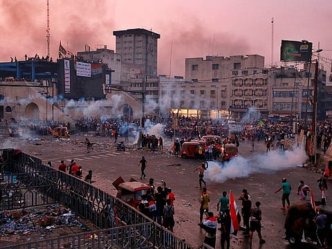 Anti-government protesters gather while Iraqi Security forces fire tear gas during a demonstration in Tahrir Square in Baghdad, Iraq, Monday, Oct. 28, 2019.