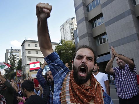 An anti-government protester shots slogans after he was attacked by Hezbollah supporters, in Beirut, Lebanon, Tuesday, Oct. 29, 2019. 