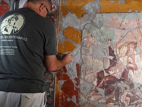 A worker renovates a fresco in the House of the Bicentenary (Casa del Bicentenario), at the archaeological site of Herculaneum in Ercolano, near Naples, on October 23, 2019. The house is to open to the public after 30 years, following a renovation carried out jointly by the Archaeological Park of Herculaneum, the Archaeological Park of Pompeii, the Herculaneum Conservation Project and the Getty Conservation Institute. - RESTRICTED TO EDITORIAL USE - MANDATORY MENTION OF THE ARTIST UPON PUBLICATION - TO ILLUSTRATE THE EVENT AS SPECIFIED IN THE CAPTION
 / AFP / ANDREAS SOLARO / RESTRICTED TO EDITORIAL USE - MANDATORY MENTION OF THE ARTIST UPON PUBLICATION - TO ILLUSTRATE THE EVENT AS SPECIFIED IN THE CAPTION