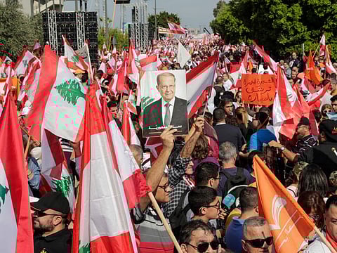 A supporter of Lebanese President Michel Aoun holds his picture during a counter-protest near the presidential palace in Baabda on November 3, 2019. Thousands of Lebanese gathered to show support to the embattled president, an AFP correspondent said, after more than two weeks of mass anti-graft protests that brought down the government. / AFP / ANWAR AMRO