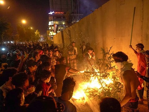 Iraqi demonstrators set tires ablaze behind the walls protecting the Iranian consulate in the Shiite Muslim shrine city of Karbala, south of Iraq's capital Baghdad, during the night of November 3, 2019. 