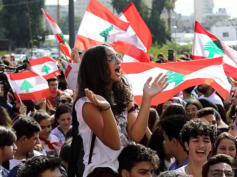 Lebanese students from various schools wave national flags and shout slogans as they gather in front of the Ministry of Education during ongoing anti-government protests, in the capital Beirut on November 7, 2019.