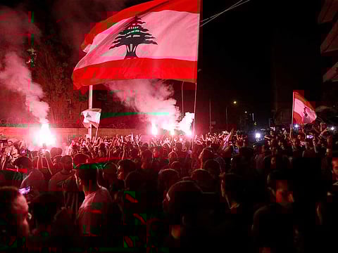 Demonstrators hold flares and Lebanese flags as they protest outside the house of former Lebanese prime minister Fouad Siniora in Beirut, Lebanon November 7, 2019