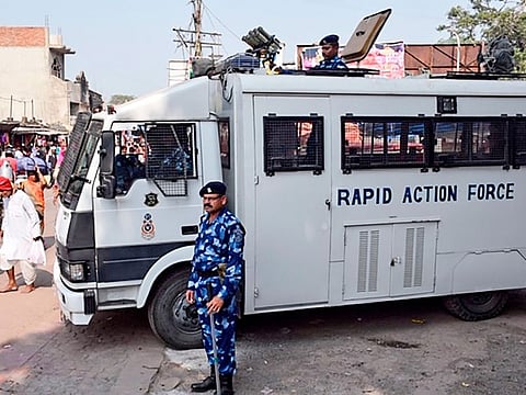 Rapid Action Force (RPF) personnel stand guard near a security vehicle on a street in Ayodhya on November 8, 2019, ahead of a Supreme Court verdict.  