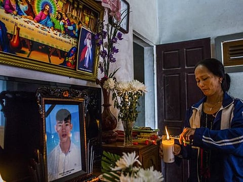 Nguyen Thi Huan, with a photograph of her son Nguyen Dinh Luong, who is feared to be among the 39 people found dead in a truck in Britain last month, at an altar at the family home in Ha Tinh Province, Vietnam, Oct. 29, 2019. The police in Vietnam arrested eight people on Monday as investigators continued to trace how 39 people, said to be Vietnamese citizens, died in a refrigerated truck in southeastern England on Oct. 23. (Minzayar Oo/The New York Times)