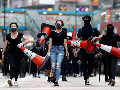 Protesters walk down the road with traffic cones to build a barricade in Causeway Bay, Hong Kong.