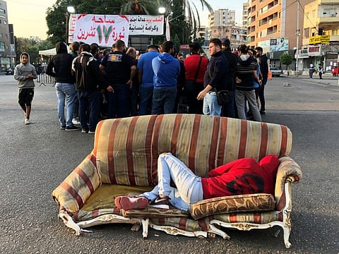 A demonstrator lies on a sofa along a street during ongoing anti-government protests, in the southern city of Sidon, Lebanon November 13, 2019. REUTERS/Ali Hashisho