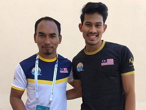 Abdul Latif Romly (right) with his coach Syahrul Amri after the men’s T20 long jump.