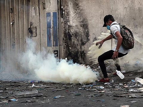 Riot police fire tear gas during clashes between Iraqi security forces and anti-government demonstrators, in downtown Baghdad, Iraq, Wednesday, Nov. 13, 2019.