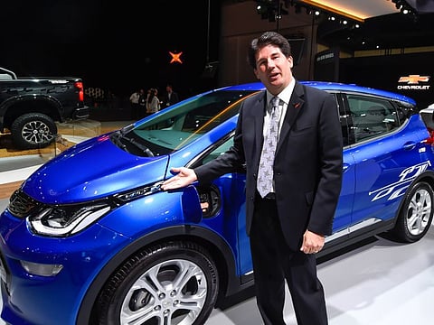 Roth poses with the Chevrolet Bolt EV at the Dubai International Motor Show.