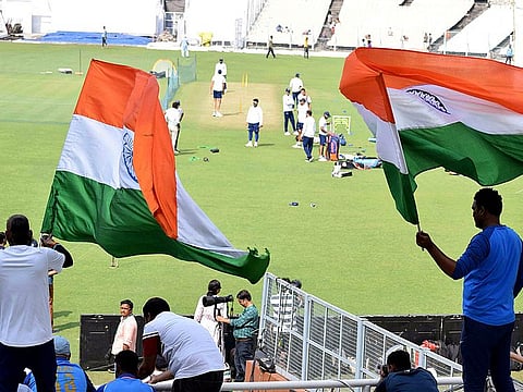 Indian cricket team supporters hoist Indian flag during the practice session ahead of first-day night test match against Bangladesh at Eden Gardens in Kolkata on Thursday. 