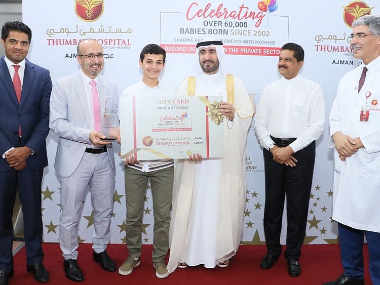 Sheikh Dr. Majid bin Saeed Al Nuaimi presenting the Gift Certificate to one of the first borns at the Thumbay Hospital Ajman Celebration Event-1574344838977
